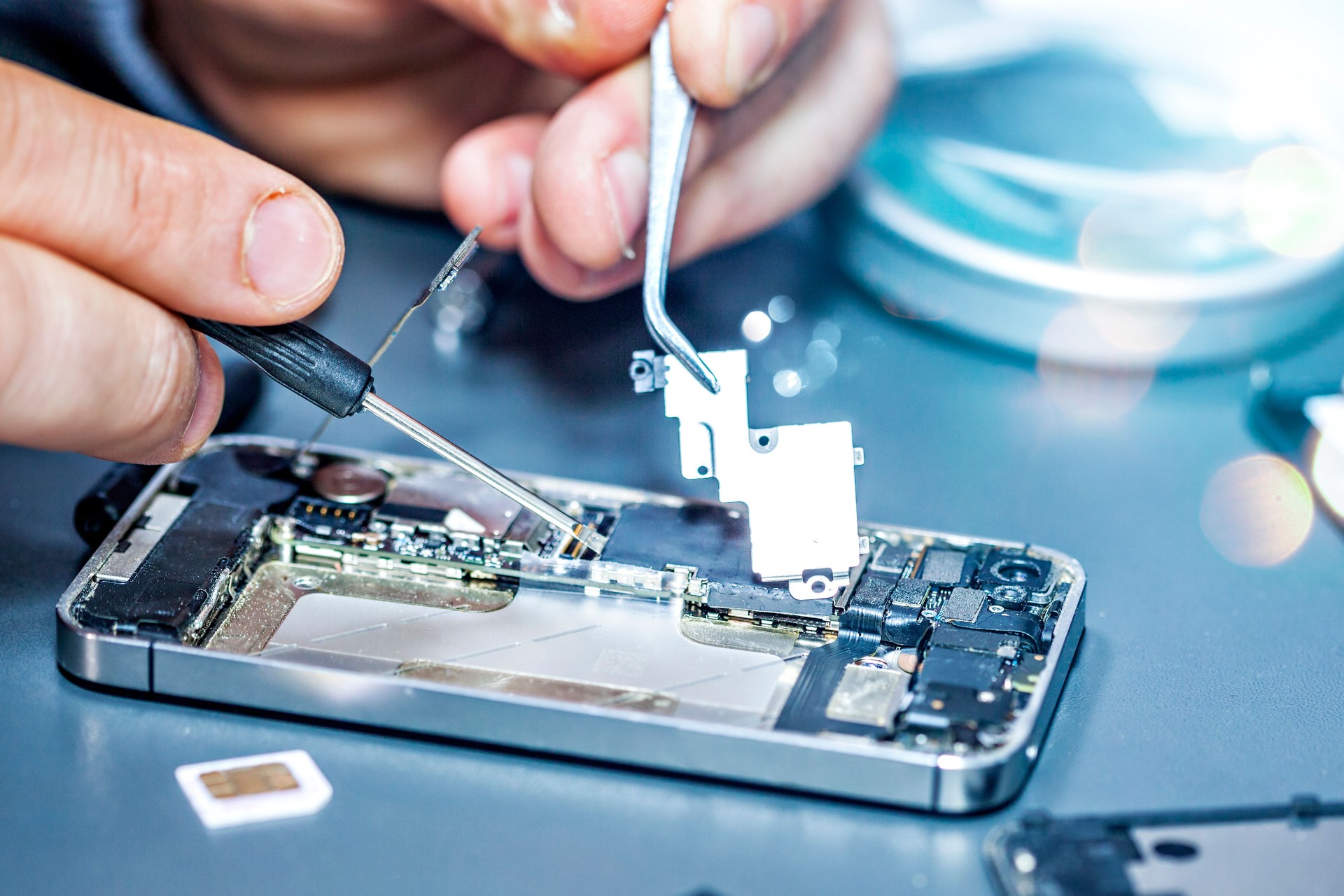 Serviceman is repairing a damaged mobile phone.